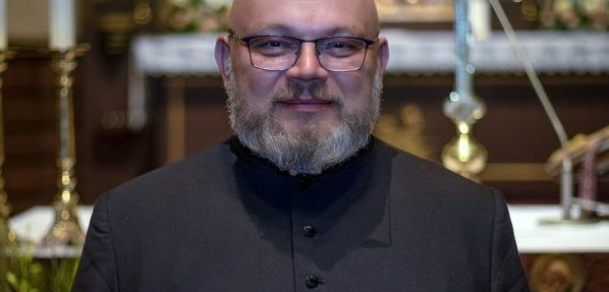 Ksiądz po drugiej stronie muru